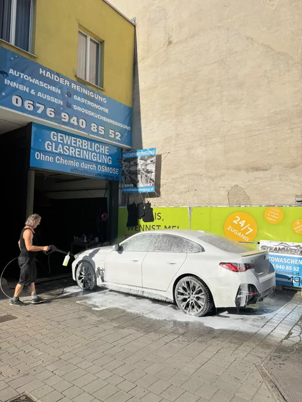 Aussenreinigung eines weißen BMW direkt vor der Werkstatt in der Breitenfurter Straße 98